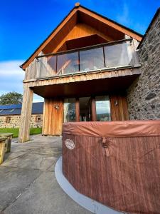 a house with a large deck on top of it at The Steading Getaway in Fetterangus
