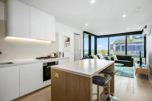 格伦韦弗利Heart of Glen Waverley Pool Gym Parking的带白色橱柜的厨房和客厅