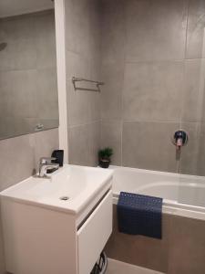 a bathroom with a sink and a bathtub and a sink at 106 Mossel Cove in Mossel Bay