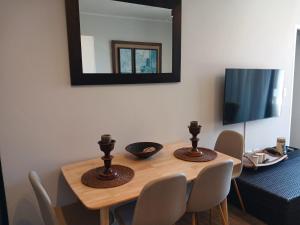 a dining room table with chairs and a mirror at 106 Mossel Cove in Mossel Bay