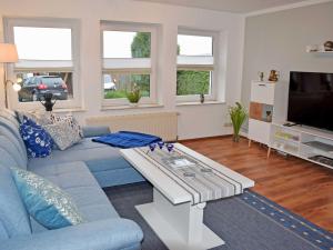a living room with a blue couch and a coffee table at Ferienwohnung Gartenblick in Altefähr