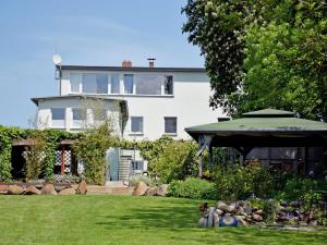 a large white house with a yard with a building at Ferienwohnung Gartenblick in Altefähr