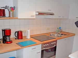 a kitchen with a counter with a stove top oven at Ferienwohnung Gartenblick in Altefähr +10 photos