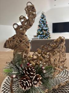 a reindeer ornament on a table with a christmas tree at 1 Old Sefter School House in Bognor Regis