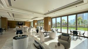 a lobby with white chairs and tables and windows at Dubai Mall Connected! AMAZING Burj Khalifa View! Excellent Pool & Gym Access! in Dubai