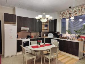 a kitchen with a table and chairs in a kitchen at Kuutamo B&B Guesthouse in Suomussalmi
