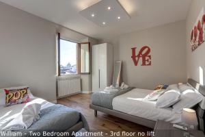 sypialnia z 2 łóżkami i dużym oknem w obiekcie Freedom Apartments by Mamo Florence we Florencji