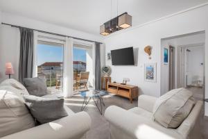 a living room with two white couches and a television at Apartments Villa Padrone with pool - perfect for families! in Garica