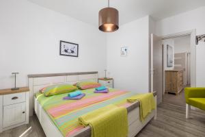 a bedroom with a bed with colorful sheets and pillows at Apartments Villa Padrone with pool - perfect for families! in Garica +61 photos
