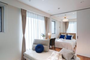 a bedroom with a bed and a chair and a mirror at Space Roppongi in Tokyo