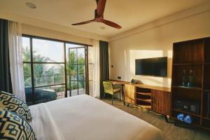 a hotel room with a bed and a television at Beach Hot Dhigurah in Dhigurah +30 photos