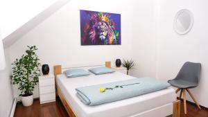 ein Schlafzimmer mit einem Bett und einem Gemälde an der Wand in der Unterkunft Jacky & Daniel's Apartments Top 2 in Sankt Pölten