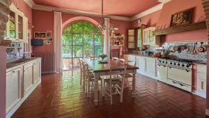 a kitchen with a table and chairs and a large window at Villa Marliana in Cerreto Guidi