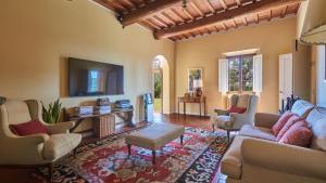 a living room with a couch and a tv at Villa Marliana in Cerreto Guidi