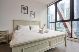 A bed or beds in a room at Borderless Swimming Pool - Invincible Twin Towers View - Free WiFi