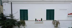 a window with green shutters on a white building at Casa Maergilù in Pescara