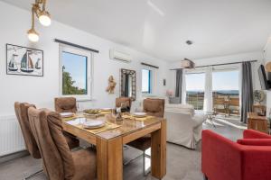 a dining room with a table and chairs and a couch at Apartments Villa Padrone with pool - perfect for families! in Garica