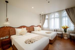 Postel nebo postele na pokoji v ubytování Me Saigon Boutique Hotel