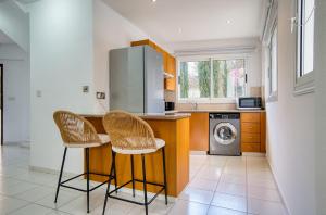 a kitchen with two chairs and a counter with a washing machine at Pafilia Gardens 6 in Paphos