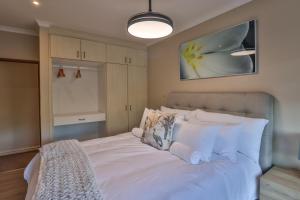 a bedroom with a large bed with white pillows at Cornerstone Connection in Durban