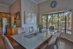 a dining room with a white table and chairs at Cornerstone Connection in Durban +7 photos
