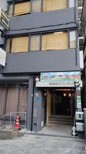 Un edificio con un cartel en el frente. en 天満橋 Guest House#有电梯 #步行大阪城 #赏樱花必打卡点 #直达梅田 京都 #免费wifi, en Osaka