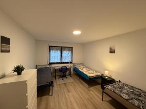 a room with two beds and a desk in it at Cosy, beautiful and central apartment in Karlsruhe