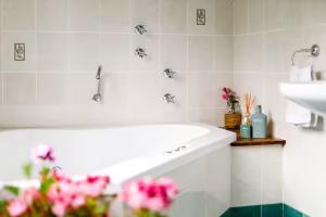un bagno bianco con lavandino e fiori di Tranquil Blue Cottage Close to Eco Point a Katoomba Altre 52 foto