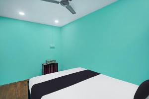 a room with a bed and a ceiling fan at Super Hotel O Grill Inn in Dhanbād