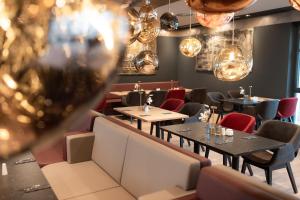 a restaurant with tables and chairs and lights at PLAZA Premium Heidelberg in Heidelberg