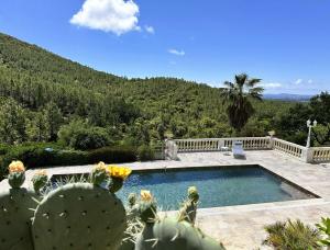 a house with a swimming pool and a cactus at Villa Blanche pour 8 personnes avec piscine privée à La Londes-Les-Maures in La Londe-les-Maures
