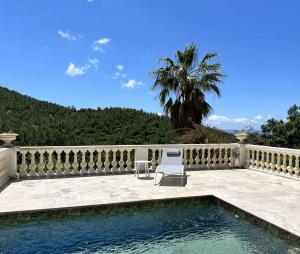 a patio with two chairs and a swimming pool at Villa Blanche pour 8 personnes avec piscine privée à La Londes-Les-Maures in La Londe-les-Maures