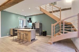 a kitchen with a staircase and a kitchen with a counter at Château des Cours - Gîte La Providence in Taillis