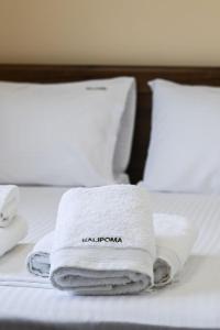 a stack of towels sitting on top of a bed at Villa Penelope Halipoma in Lefkada Town