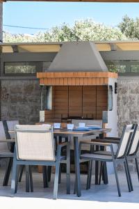 a picnic table and chairs on a patio at Villa Penelope Halipoma in Lefkada Town