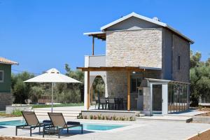 a house with a pool and chairs and an umbrella at Villa Penelope Halipoma in Lefkada Town