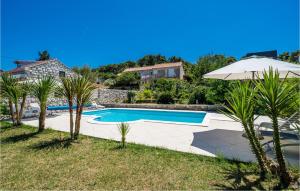 a swimming pool with an umbrella and palm trees at Nice Apartment In Zaton Veliki With Wifi in Zaton