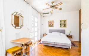 a bedroom with a bed and a table and a ceiling fan at Nice Apartment In Zaton Veliki With Wifi in Zaton