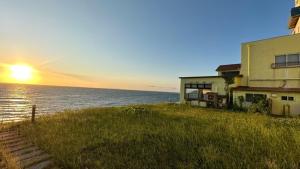 a house on the shore of the ocean with the sunset at Taiseisou - Vacation STAY 90032v in Murakami