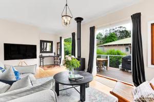 a living room with a couch and a table at Tranquil Blue Cottage Close to Eco Point in Katoomba