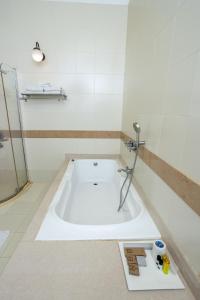 a bath tub in a bathroom with a shower at Koder House in Cochin