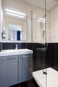 a bathroom with a shower and a sink and a mirror at Saint Aubin Logis Hôtel & Restaurant in Saint-Aubin-sur-Mer