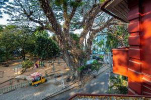 a view of a street with a tree and a yellow truck at Koder House in Cochin