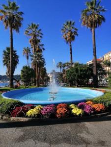 a fountain in a park with palm trees and flowers at Casa Noemi, nel cuore di Varazze, ad un passo dal mare in Varazze