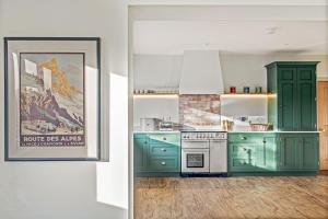 een keuken met groene kasten en een foto aan de muur bij Far Heath House with Hot Tub in Coton +51 foto's