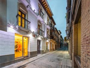 an empty street in an old town at night at Hostal Arriola in Granada