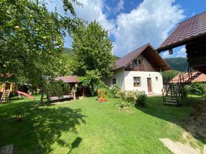 a backyard of a house with a yard with a playground at La Mili in Grinţieşu Mic