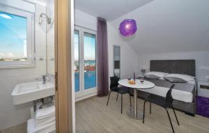 a bedroom with a bed and a table and a bathroom at Cozy Apartment In Rogoznica With Sauna in Rogoznica