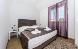 a bedroom with a large bed with two towels on it at Nice Apartment In Rogoznica With Sauna in Rogoznica