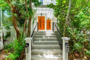 a staircase leading to a house with a orange door at Wyakha 4 Ocean View in Long Bay Hills